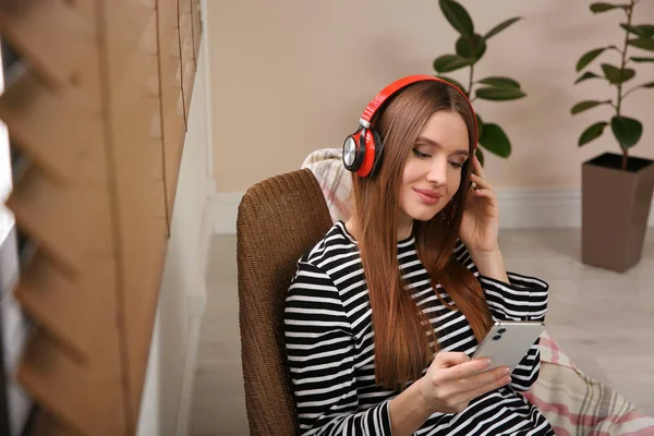 Žena poslouchající audioknihu doma v křesle — Stock fotografie