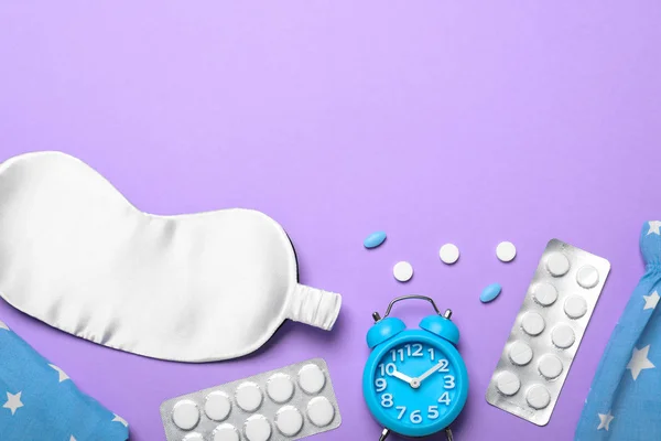 Flat lay composition with sleeping mask on violet background, space for text. Bedtime accessories