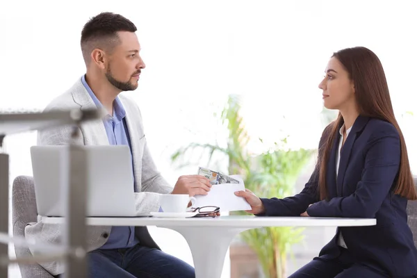 Vrouw Geeft Steekpenningen Aan Man Aan Tafel Binnen — Stockfoto