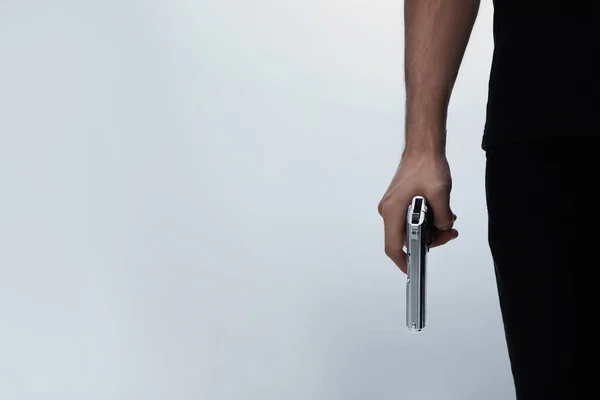 Професійний вбивця з пістолетом на білому тлі, крупним планом — стокове фото