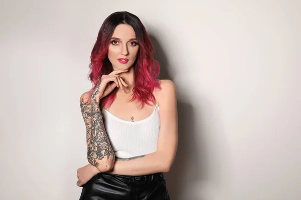Vacker Kvinna Med Tatueringar Armar Mot Ljus Bakgrund — Stockfoto