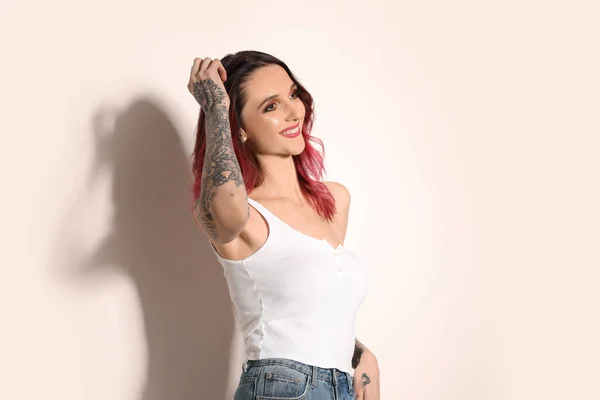 Mulher Bonita Com Tatuagens Nos Braços Contra Fundo Claro — Fotografia de Stock
