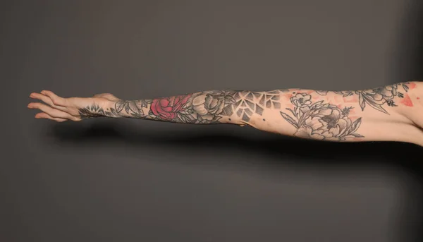 Žena Barevnými Tetováními Paži Proti Tmavě Šedému Pozadí Detailní Záběr — Stock fotografie