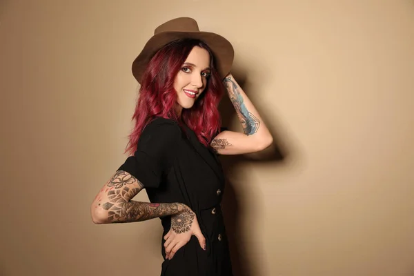 Mooie Vrouw Met Tattoos Armen Tegen Beige Achtergrond — Stockfoto