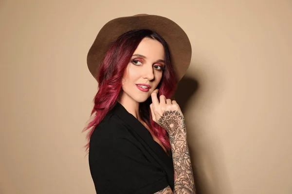 Mooie Vrouw Met Tattoos Armen Tegen Beige Achtergrond — Stockfoto