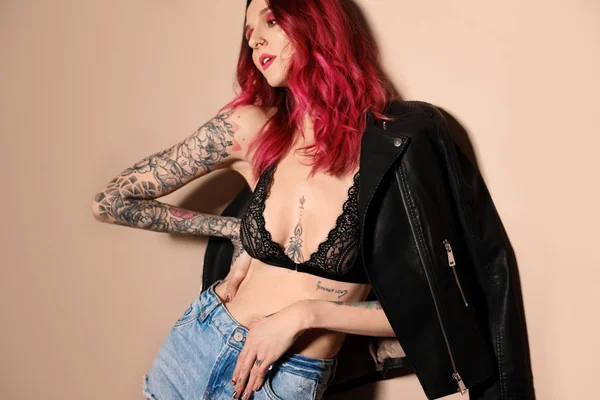Vacker Kvinna Med Tatueringar Kroppen Mot Beige Bakgrund — Stockfoto