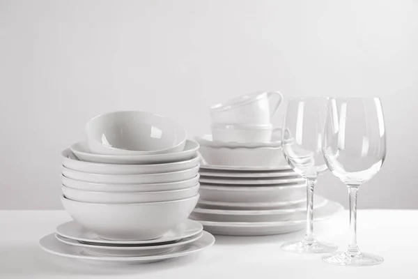 Set de platos limpios sobre mesa blanca —  Fotos de Stock