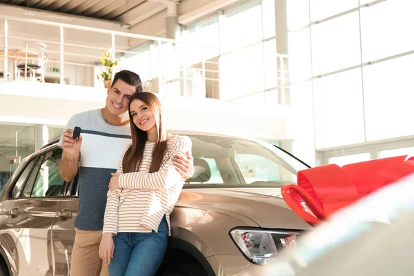 Coppia Felice Con Chiave Della Macchina Nella Moderna Concessionaria Auto — Foto Stock