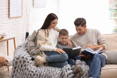 Evde kitap okuyan küçük oğlu olan mutlu bir aile. Kış tatili