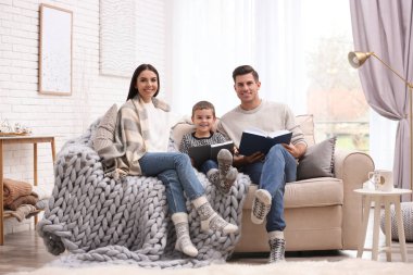 Evde kitap okuyan küçük oğlu olan mutlu bir aile. Kış tatili