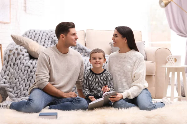 Een gelukkig gezin met een zoontje dat thuis een boek leest. Wintervakantie — Stockfoto
