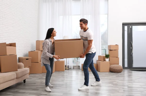 Happy couple in room with cardboard boxes on moving day — 스톡 사진