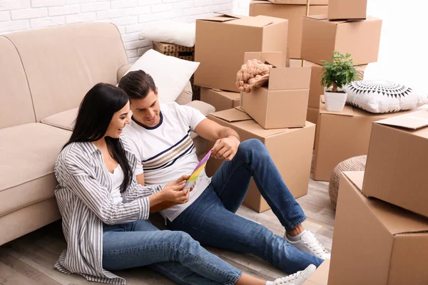 Glada par med färgpalett prover i sin nya lägenhet på mov — Stockfoto