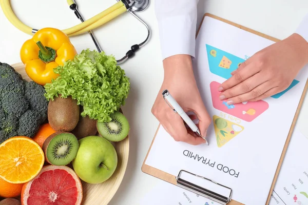 Vrouwelijke Voedingsdeskundige Met Voedsel Piramide Kaart Aan Tafel Bovenaanzicht — Stockfoto