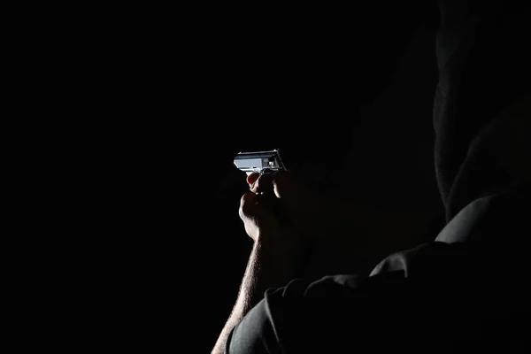 Επαγγελματίας δολοφόνος με όπλο σε μαύρο φόντο, κοντινό πλάνο — Φωτογραφία Αρχείου