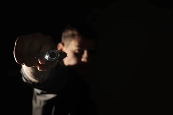 Asesino profesional sobre fondo negro, enfoque en arma — Foto de Stock