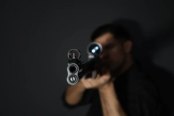 Professional killer on black background, focus on sniper rifle — Stock Photo, Image