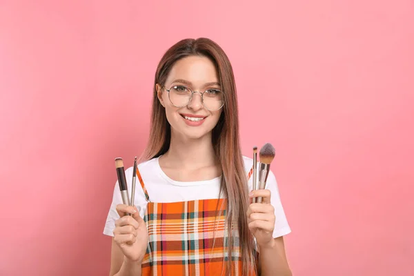 Blogger de belleza con conjunto de pinceles de maquillaje sobre fondo rosa — Foto de Stock