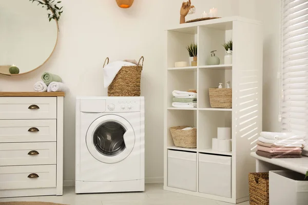 Современная стиральная машина возле белой стены в элегантной ванной комнате — стоковое фото