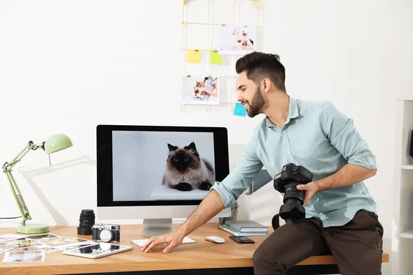 Professional photographer with camera working in light modern office