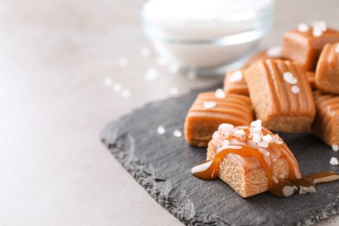 Açık gri masada tuzlu karamel, yakın plan. Metin için boşluk
