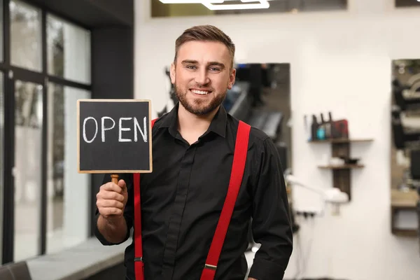 Young business owner holding OPEN sign in his barber shop — 스톡 사진