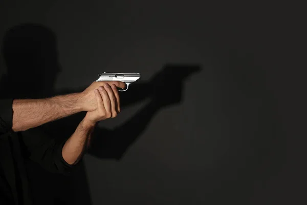 Profesjonalny zabójca z bronią na czarnym tle, zbliżenie — Zdjęcie stockowe