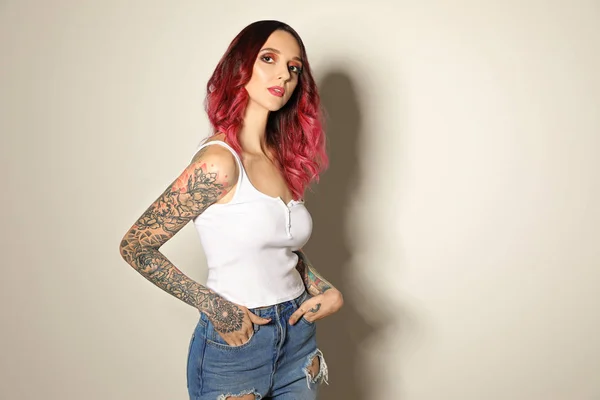 Mulher Bonita Com Tatuagens Nos Braços Contra Fundo Claro — Fotografia de Stock