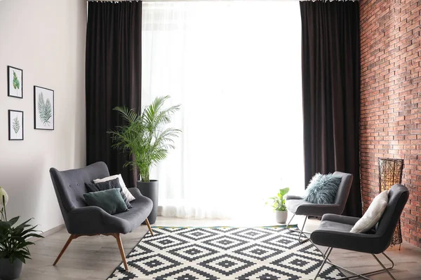 Pohodlná pohovka a židle v blízkosti okna s elegantními závěsy v — Stock fotografie