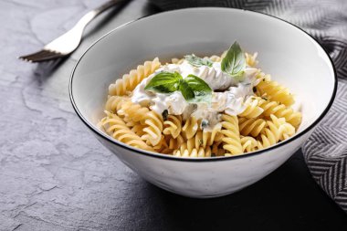 Siyah masada servis edilen soslu lezzetli makarna, yakın plan.