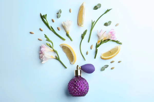 Красивая композиция с бутылкой духов, лимона и цветов — стоковое фото