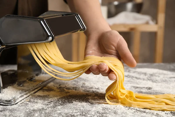 Nő készítés tészta tésztakészítő gép asztalnál beltéri — Stock Fotó