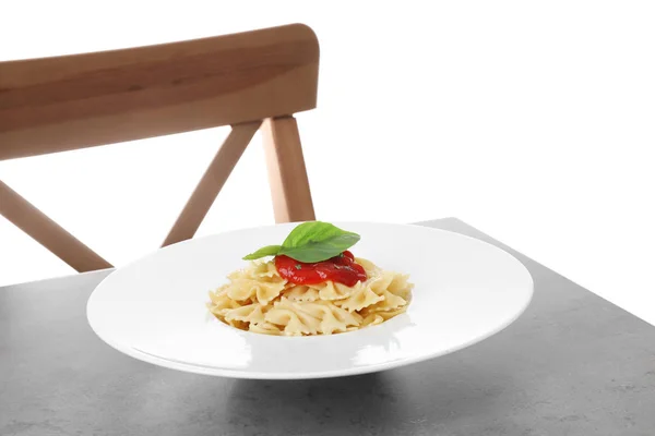 Deliciosas massas farfalle com molho de tomate servido em mesa cinza — Fotografia de Stock