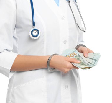 Beyaz arka planda rüşvetle kelepçelenmiş bir doktor, yakın plan. Cor