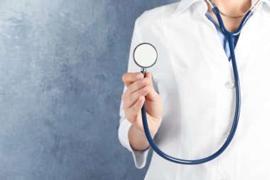 Mavi arka planda steteskobu olan doktor, yakın plan. Tıbbi hizmet