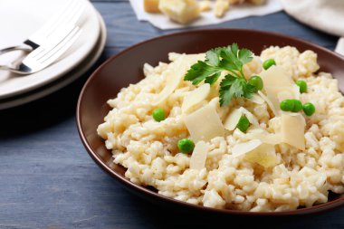 Mavi ahşap masada peynirli leziz risotto, yakın plan.