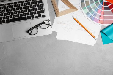 Düz kompozisyon dizüstü bilgisayarı ve aksesuarları gri taş masa üzerinde, metin için boşluk. Tasarımcının işyeri