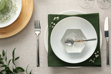 Açık renk kumaşlı yeşil bitkilerle süslü zarif bir masa.