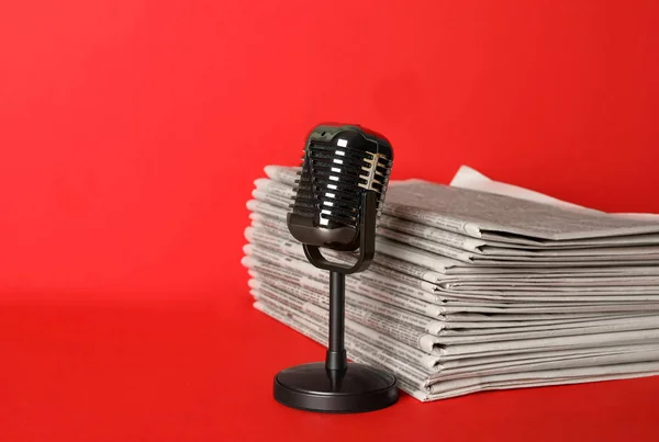 Gazety i zabytkowy mikrofon na czerwonym tle, miejsce na t — Zdjęcie stockowe