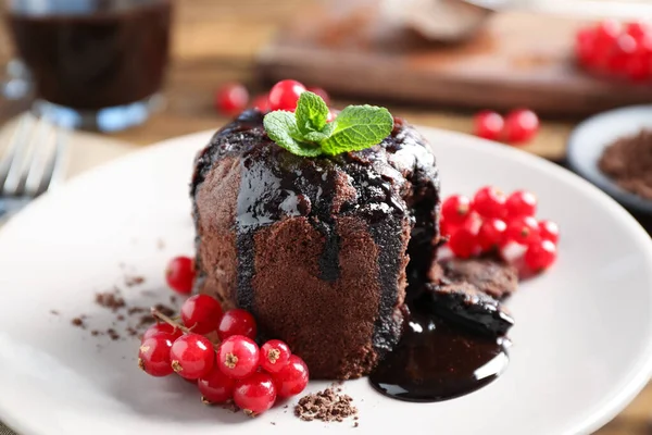 Stock image Delicious warm chocolate lava cake with mint and berries on plate, closeup