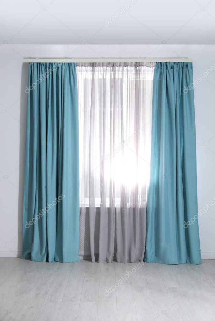 Window with elegant curtains in empty room