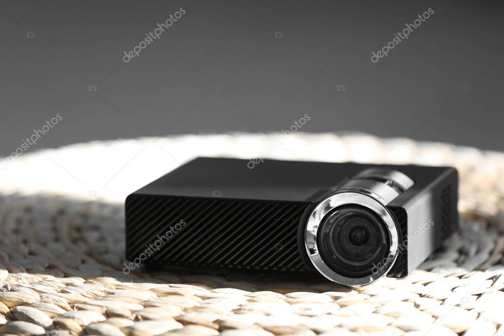 Modern video projector on wicker pouf indoors