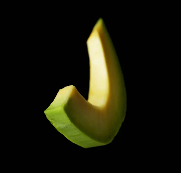 Fatia de abacate fresco no fundo preto — Fotografia de Stock