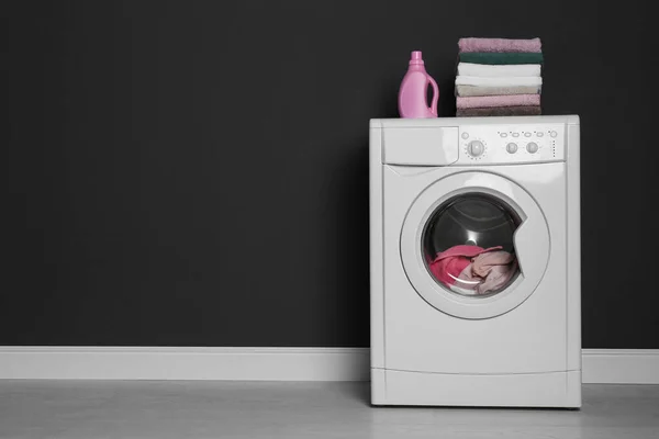 Moderní pračka s prádlem, stohem ručníků a odstrašujícím prostředkem — Stock fotografie