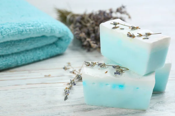 Natural handmade soap bars on white wooden table, closeup. Space for text