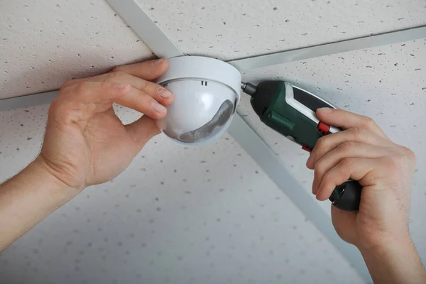 Técnico de instalação de câmera CCTV no teto dentro de casa, close-up — Fotografia de Stock