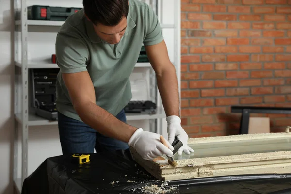 Man repareert oude beschadigde raam aan tafel binnen — Stockfoto