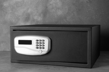 Siyah çelik kasa ve gri masada elektronik kilit.