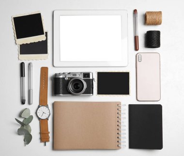 Tablet, kamera ve akıllı telefonlu düz kompozisyon beyaz masanın üzerinde. Tasarımcının işyeri
