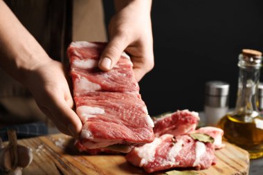 Masada çiğ pirzola tutan adam, yakın plan.